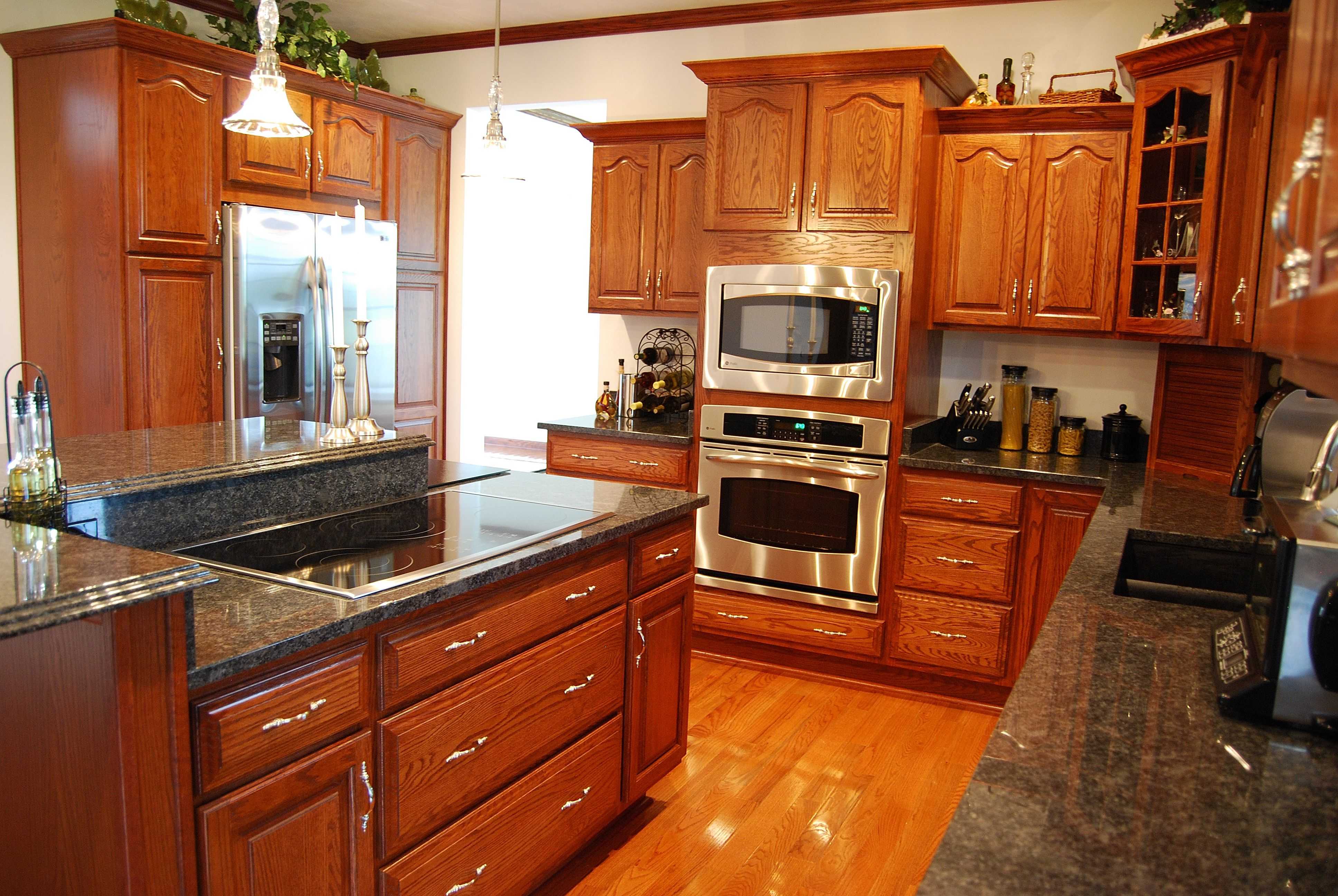Kitchen with rich wood cabinetry, dark granite countertops, and stainless steel appliances