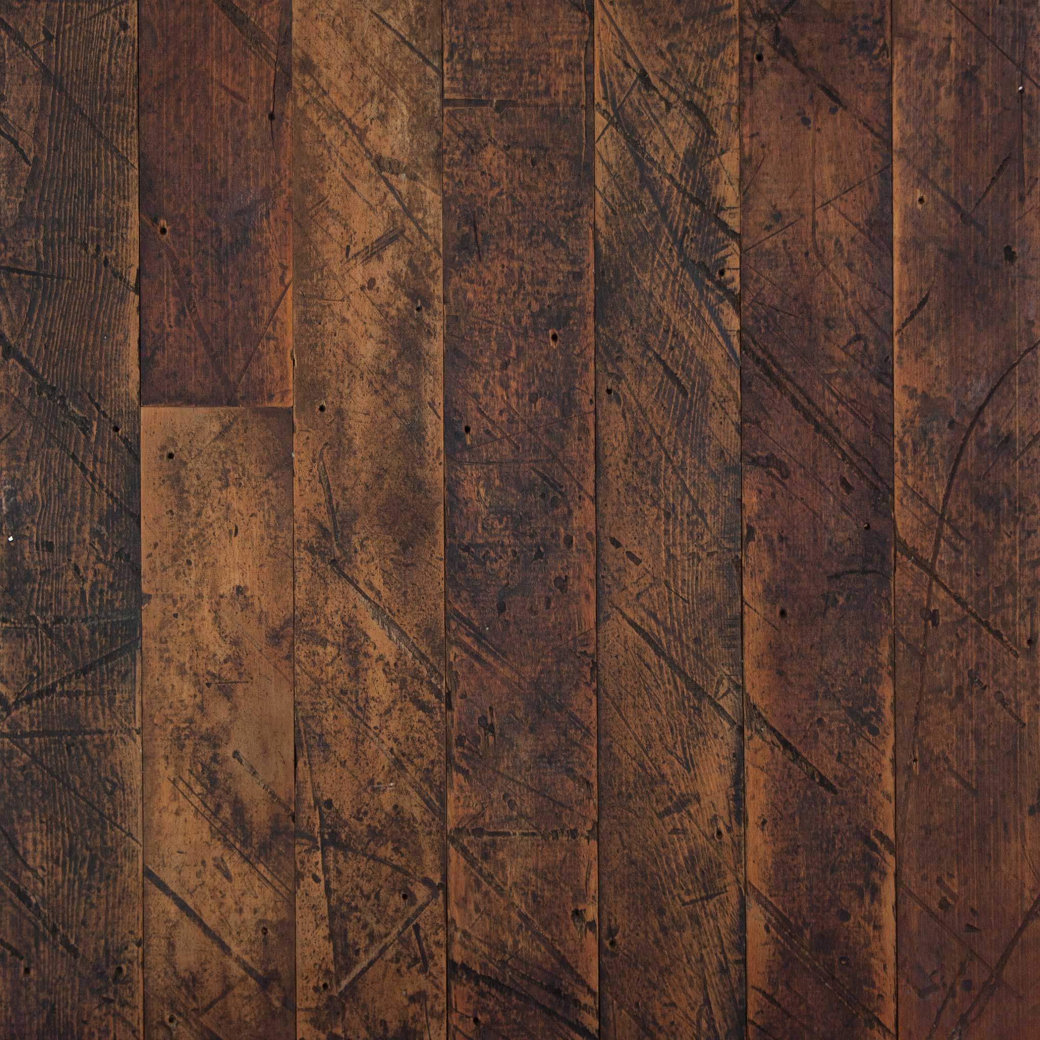 Close-up of worn, scratched wooden plank flooring in warm brown tones